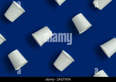Pattern made with white paper cups on blue background. Stock Photo