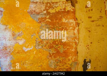 detail of worn wall mostly in yellow-orange shades suitable for vibrant backgrounds Stock Photo