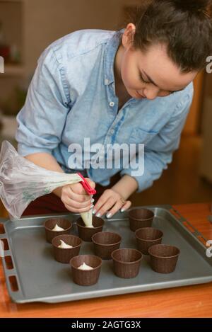 Step by step. Scooping batter with a cupcake scoop to make unicorn  chocolate cupcakes with buttercream frosting Stock Photo - Alamy