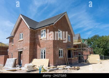 Large new build red brick house under construction in summer with blue sky above, Oakham, Rutland, UK Stock Photo