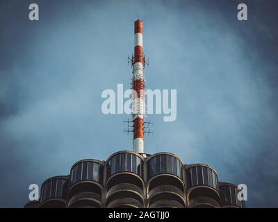 View from bottom to top of a red and white painted radio antenna on a skyscraper Stock Photo