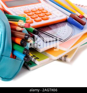 Various school supplies including notebooks, calculator and pencil case isolated against a white background Stock Photo