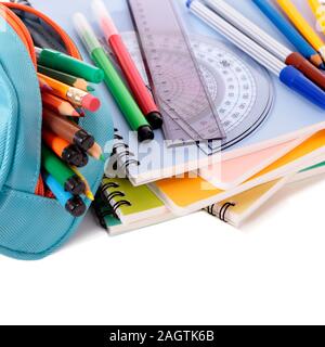 Various school supplies including notebooks and pencil case isolated against a white background Stock Photo