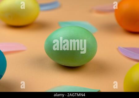Easter composition of multicolored colorful easter eggs and feathers on pastel background. Happy Easter holidays. Stock Photo