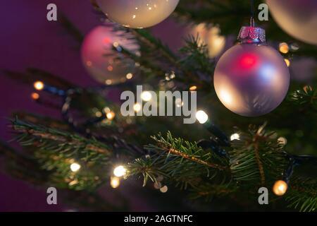 Beautiful detail of Christmas ornaments and lights on a real Christmas tree. Christmas, holidays and seasonal greetings concepts. Stock Photo
