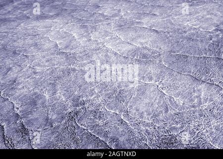 Empty abstract background naturally created by small sea waves in shallow waters and sunlight reflections on water surface. Toned in blend of gray blu Stock Photo