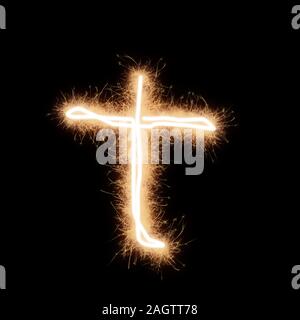 Lower case t letter of alphabet written by squib sparks on a black background. Stock Photo