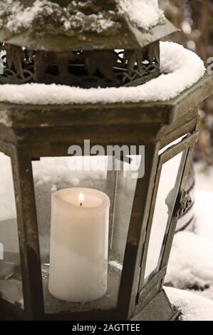 Burning Candle in a lantern with snow closeup by jziprian Stock Photo