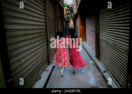 November 2019, LUXOR, EGYPT - Moslem People of Egypt go shopping at Luxor Souq - two women wear bright red dresses from behind Stock Photo