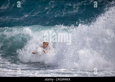 Palm Beach, Florida, USA. 21st Dec, 2019. BAILEY SPIEGEL, of Upland, Indiana plays in the surf in Palm Beach, Florida. A low-pressure system is developing in the Gulf of Mexico and could cause storms -- and even tornadoes -- in southern Florida starting Saturday. The National Weather Service in Miami is predicting severe storms, heavy rain and flooding through Sunday. Credit: Greg Lovett/ZUMA Wire/Alamy Live News Stock Photo