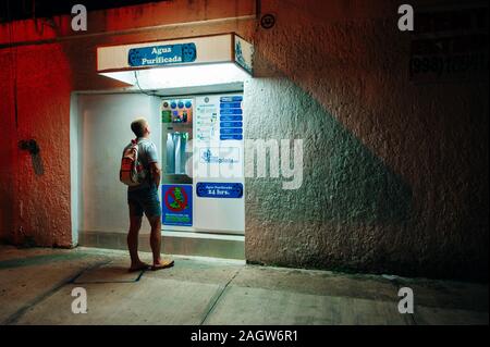 cancun, Mexico - October 2019 Back view of young male using ATM cash point Stock Photo