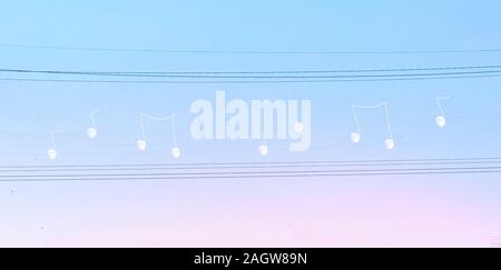 Creative manipulated surrealisstic abstract photo of the white moon on electric wires on a blues pink sky background. Stock Photo
