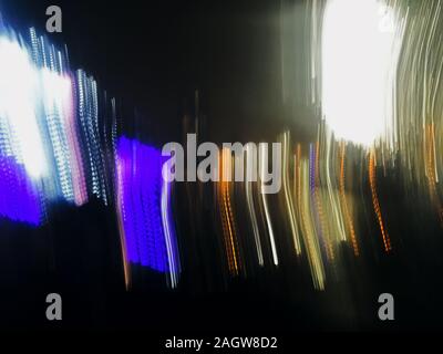 Abstract long exposure defocused photo of neon lines of city lights of phantom blue, yellow and white colors at night Stock Photo