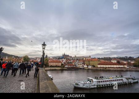 PRAGUE, CZECHIA - NOVEMBER 2, 2019: Tourist taking a selfie on Charles bridge, or Karluv Most, crowded with visitors, over the Vltava river with the P Stock Photo