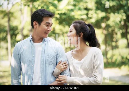 loving young asian couple relaxing outdoors in park Stock Photo