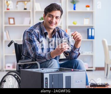 The computer repairman on wheelchair working Stock Photo