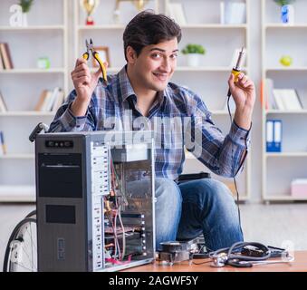 The computer repairman on wheelchair working Stock Photo