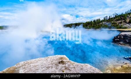 The blue-turquoise water of the Excelsior Geyser Crater in the Lower Geyser Basin at the Grand Prismatic Spring Trail in Yellowstone National Park, WY Stock Photo