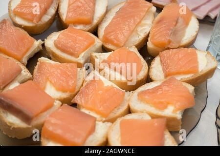 sandwiches with red fish laid out on a dish and stand on a table Stock Photo