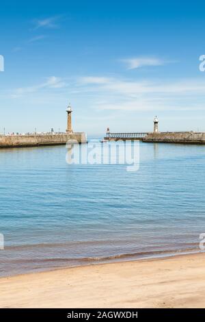 The east and west piers at the entrance to the seaside town of Whitby in Yorkshire, Northern England as a boat enters the harbour. Stock Photo