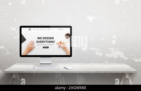 Web design studio with computer  display and modern agency web page. Copy space beside. Modern, flat  studio desk Stock Photo