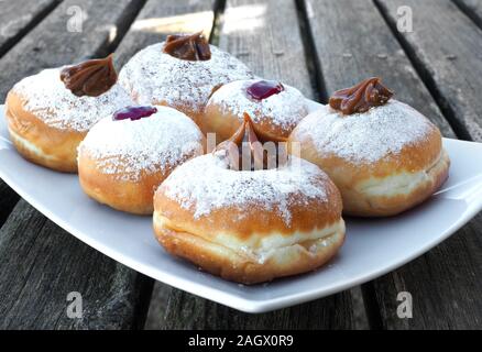 Six delicious donuts with different fillings on a wooden old table. Stock Photo