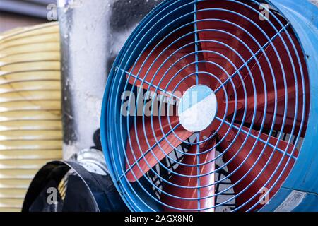 New ventilation fan. There's wire protection in front of the propeller. The wings are red in blue. Stock Photo