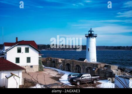 The landmark portsmouth harbor lighthouse covered in snow in New Castle New Hampshire on a sunny blue sky day. Stock Photo