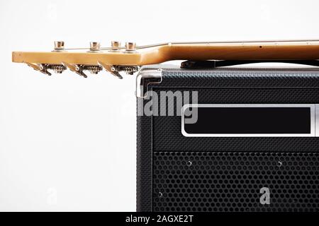Electric bass guitar on black amplifier against white background with copy space. Close up detail. Stock Photo