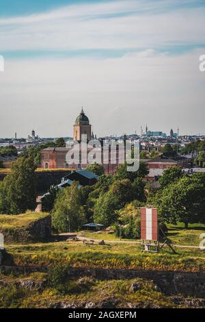 Suomenlinna sea fortress with the old buildings and lighthouse with Helsinki city in the background at summer, Helsinki Finland Stock Photo