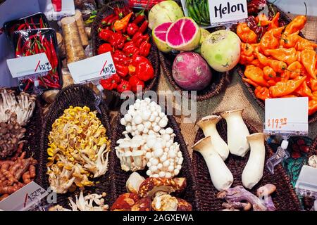 Vegetables in basket on the organic farmers market stall. Special mushrooms, red pepper, radish, king oyster, enoki, golden oyster, and honey fungus. Stock Photo