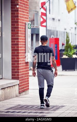 Montreal, Canada - June, 2018: Sportive young man with his body covered with tattoos walking on the street in Montreal, Quebec, Canada. Stock Photo