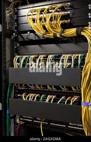 Yellow network cables and servers in a technology data center Stock Photo
