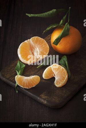 Satsumas ,easy peelers on dark wooden background Stock Photo