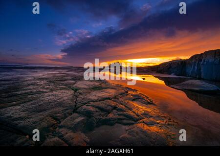 Bamburgh Castle, sunrise over this iconic English castle on the north east coast once the ancient capital of Northumbria Stock Photo