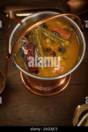 Spicy South Indian lentil, moringa and carrot stew served in copper serving pail Stock Photo