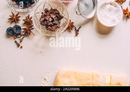 Cooking delicious sweets with jam and cinnamon and powder to tea.Top view. Vase with chocolate in powdered powder and a plate of powder and dried plum Stock Photo