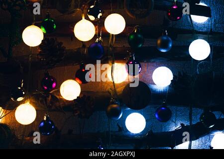 Close Up of multi coloured bauble hanging from a decorated Christmas tree. Stock Photo
