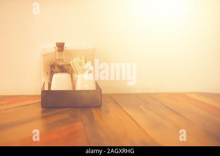 Salt pepper sauces vinegar toothpicks napkins on the vintage wooden table in a cafe Stock Photo