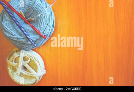 Two reel thread with red and blue knitting hook on the desk Stock Photo