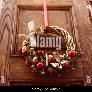 Christmas Wreath Hanging Outside On Door In Winter Made Of Tree