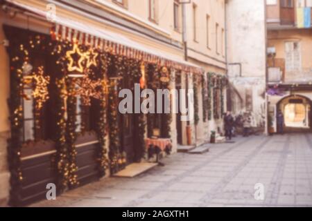 Defocused background. Beautiful empty street at Christmas, decorated restaurant with lights and garlands, blurred backdrop for design Stock Photo
