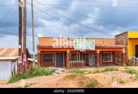 Typical low-rise roadside village shops including a herbal medicine shop and buildings for local people in the Western Region of Uganda Stock Photo