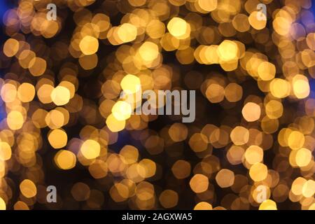 Blurred defocused picture of Christmas tree golden lights in the night, festive background for design Stock Photo