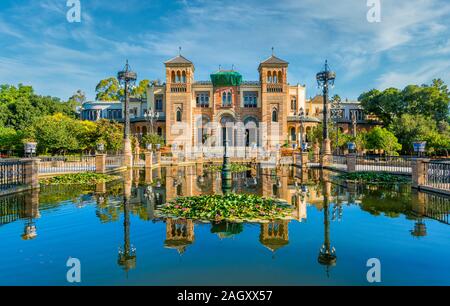 Museum of Popular Arts and Traditions reflecting in the near fountain in Seville, Andalusia, Spain. Stock Photo