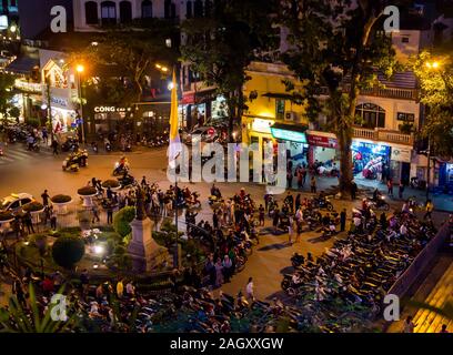 Motorbikes and people in crowded square at night, Hoan Kiem District, Hanoi, Vietnam, Asia Stock Photo
