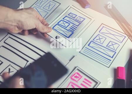 ux graphic designer sketching wireframe for mobile app and website development Stock Photo