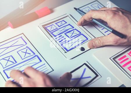 ux graphic designer sketching wireframe for mobile app and website development Stock Photo