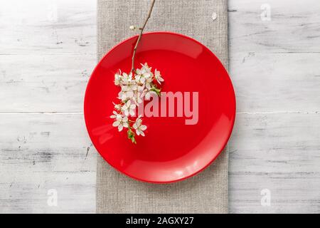 Spring table set with plates and blooming white flowers branch Stock Photo