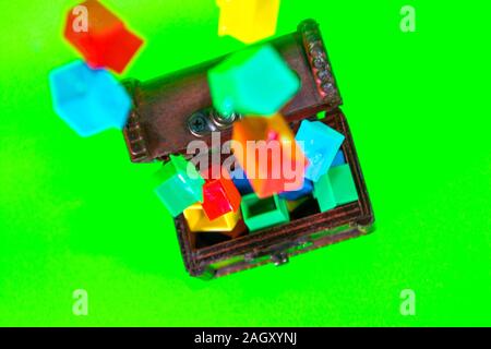 A wooden chest full of plastic houses, taken against a green screen background. Stock Photo